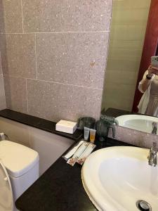 a bathroom with a sink and a toilet and a mirror at J&Q Hotel in Sihanoukville