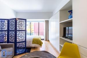 a bedroom with a bed and a tv in a room at Almada Story Apartments by Porto City Hosts in Porto