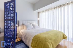 a bedroom with a large bed with a yellow blanket at Almada Story Apartments by Porto City Hosts in Porto