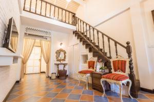 a hallway with a staircase and two chairs at Chuchaiburi Sri Amphawa in Amphawa