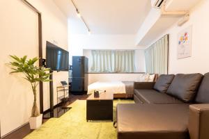 a living room with a couch and a bed at Ruis Hakata in Fukuoka