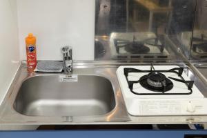 a stainless steel kitchen sink with a stove at Ruis Hakata in Fukuoka