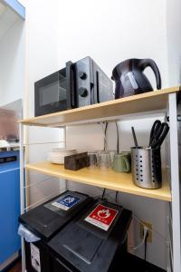 a shelf with a microwave and a coffee maker on it at Ruis Hakata in Fukuoka +105 photos