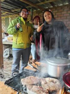 a group of people standing around a grill at Hospedaje Hacienda Norabuena in Recuay