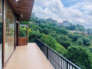 a balcony of a house with a view of trees at Mimoza homestay cầu đất in Xuân Trường