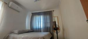 a small bedroom with a bed and a window at La cubana in Santo Domingo