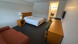 a hotel room with a bed and a couch at Midtown Inn SSK in Saskatoon
