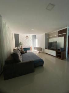 a living room with a bed and a television at Casa para temporada Diversão e sossego PRÓXIMA A PRAIA in Rio das Ostras +26 photos