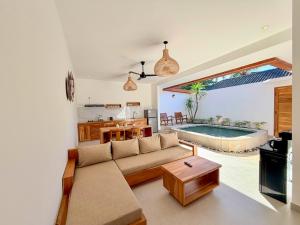 a living room with a couch and a swimming pool at Yamore Villa in Gili Islands