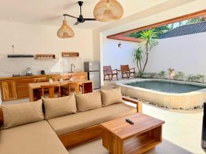 a living room with a couch and a kitchen and a pool at Yamore Villa in Gili Islands