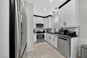 a kitchen with white cabinets and a stainless steel refrigerator at The Windsor Mainstay in Windsor