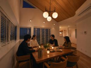 a group of people sitting around a wooden table at Smile House Akiya in Hayama +64 photos