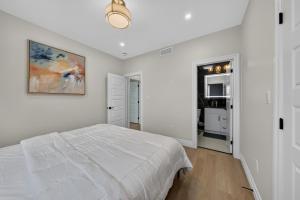 a white bedroom with a bed and a painting on the wall at The Windsor Mainstay in Windsor