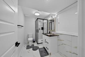 a white bathroom with a toilet and a sink at The Windsor Mainstay in Windsor +34 photos
