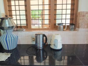 eine Arbeitsplatte mit Kaffeemaschine und Mixer in der Unterkunft Shield Guest Accommodation in Pudunagaram