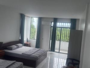 a bedroom with a bed and a large window at J&Q Hotel in Sihanoukville