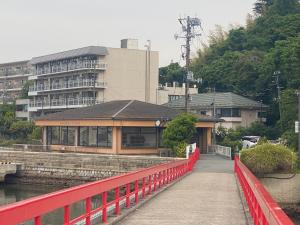 a red bridge over a river with a building at ウェルカムイン松島 in Matsushima