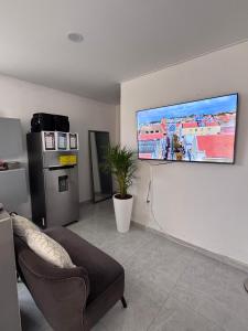 a living room with a couch and a tv on the wall at The Almas Apartment in Willemstad