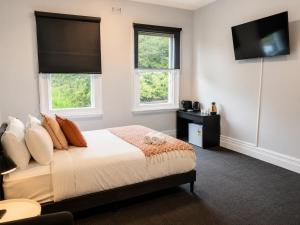 a bedroom with a bed and a flat screen tv at Heritage-Style Boutique Hotel, Port Melbourne in Melbourne +12 photos