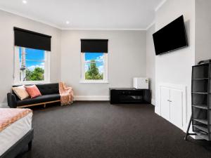 a living room with a couch and a tv at Heritage-Style Boutique Hotel, Port Melbourne in Melbourne