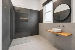 a bathroom with a shower and a sink and a mirror at Heritage-Style Boutique Hotel, Port Melbourne in Melbourne