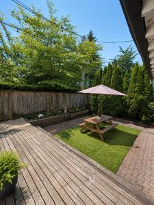 a wooden deck with a picnic table and an umbrella at Evergreen House in Vancouver