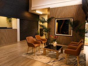 a lobby with chairs and a table and a mirror at Sails Motel Geraldton in Geraldton
