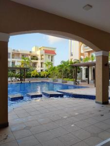 a swimming pool in a resort with an archway at Oshana Stays,Fully furnished Studio Apartment with Pool,Sauna,Siolim, Goa in Mapusa