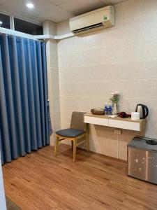 a room with a desk and a blue curtain at Omeli homestay in Hanoi