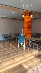 a dining room with tables and chairs and a chalkboard at Bagwan Kainchi Stay in Bhowāli