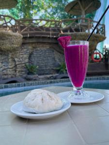 a drink and a plate of food on a table at Coastal Haven Resort in Siquijor