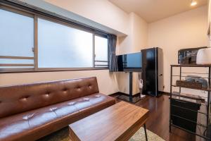 a living room with a couch and a large window at Ruis Hakata in Fukuoka