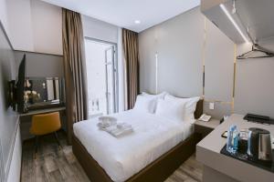 a hotel room with a bed and a desk and a window at VIN HOTEL in Vĩnh Long