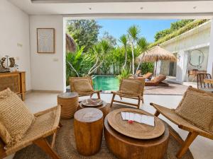 a living room with a table and chairs and a pool at Villa Mei 2BR Pool, 200m from Seseh Beach in Dalung