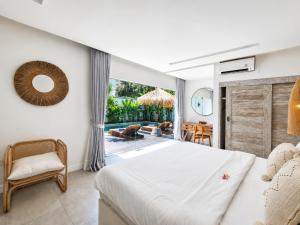 a bedroom with a bed and a view of a pool at Villa Mei 2BR Pool, 200m from Seseh Beach in Dalung +16 photos