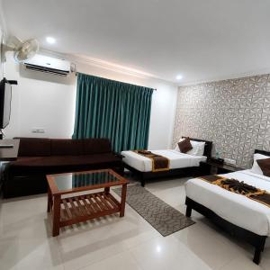 a living room with two beds and a couch at HOTEL SQUARE INN Cosmopolitan in Bangalore +4 photos