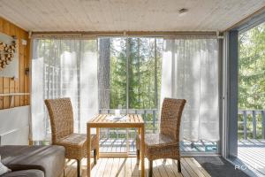 a room with a table and chairs on a balcony at Villa Repovesi in Hillosensalmi