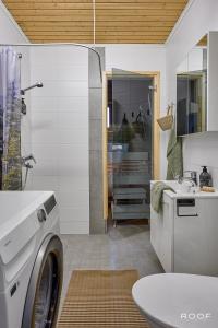 a bathroom with a washing machine and a sink at Villa Repovesi in Hillosensalmi