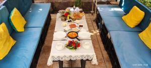 a table with plates of food on top of blue couches at Moy dom Ganja in Bagbanlar
