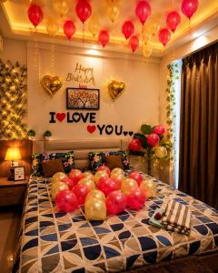 a bed with a bunch of balloons on it at The Sky cabin in Greater Noida