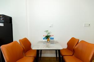 a table in a room with orange chairs and a small table with a table at The BHA Riverside in Danang