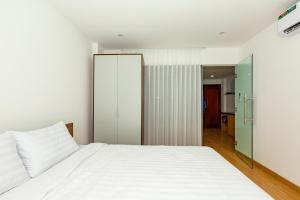 a bedroom with a white bed and a sliding glass door at The BHA Riverside in Danang +19 photos
