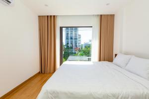 a bedroom with a large bed and a large window at The BHA Riverside in Danang