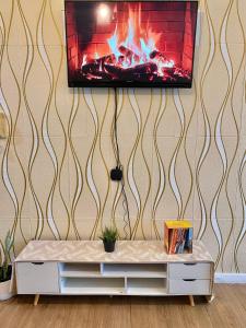 a living room with a fireplace and a tv on a wall at Abreeza place tower 1 in Davao City