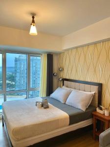 a bedroom with a large bed with a large window at Abreeza place tower 1 in Davao City
