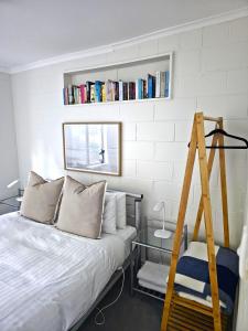 a bedroom with a bed and a ladder and books at Tide & Timber - Adventure Bay in Adventure Bay