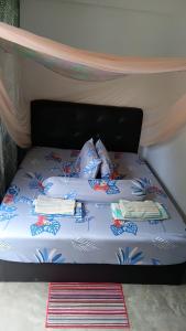 a bed with two pillows on top of it at Ilham inn in Jerantut