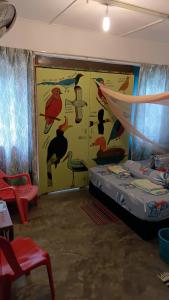 a bedroom with a bed with a painting of birds at Ilham inn in Jerantut