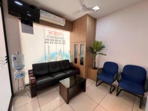 a waiting room with a leather couch and two blue chairs at Peace Residency in Jāmb