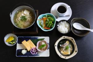 a table with bowls of food and a cup of coffee at Toyooka Sky Hotel in Toyooka